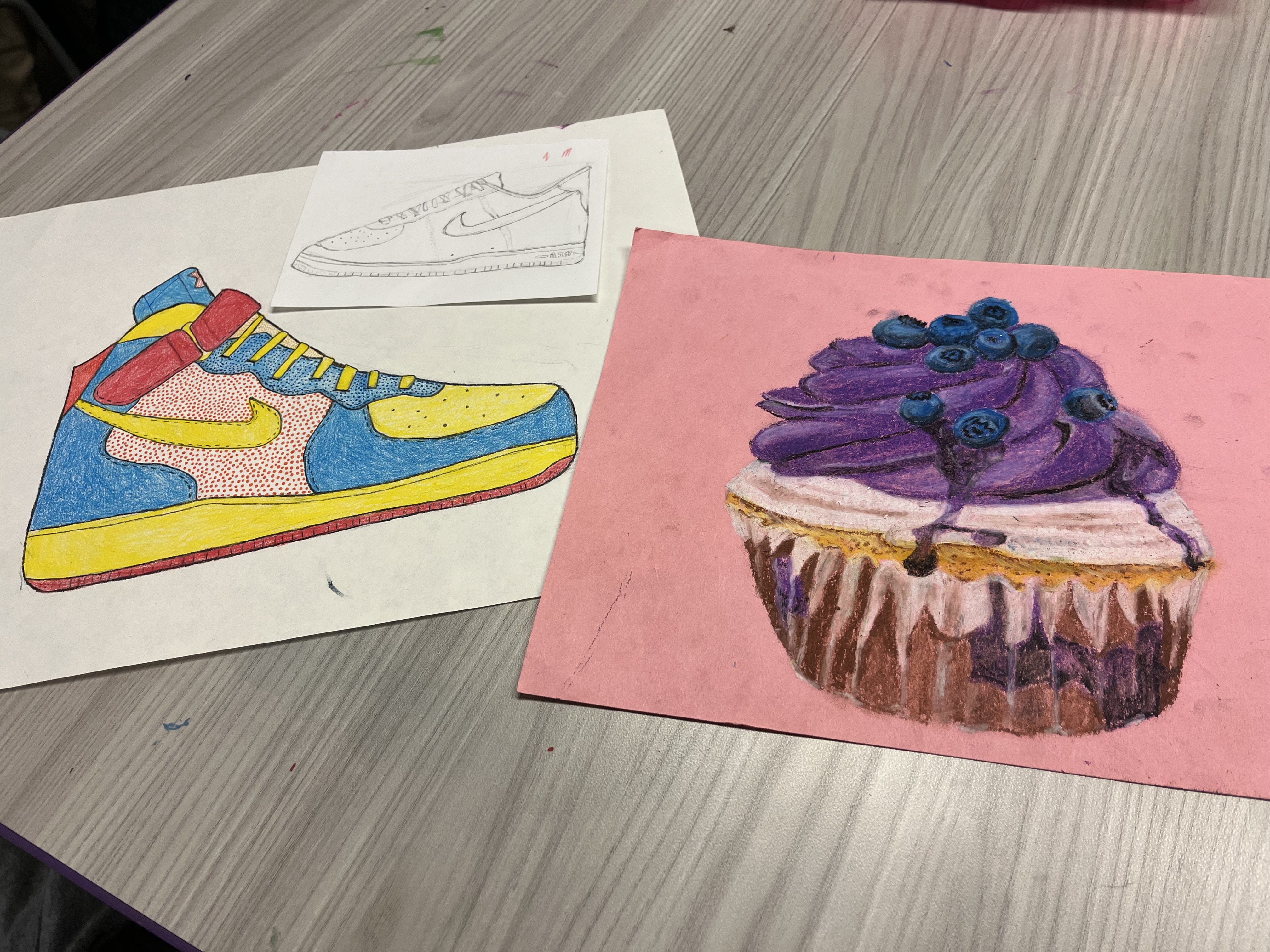 Two drawings of a show and a drawing of a cupcake
